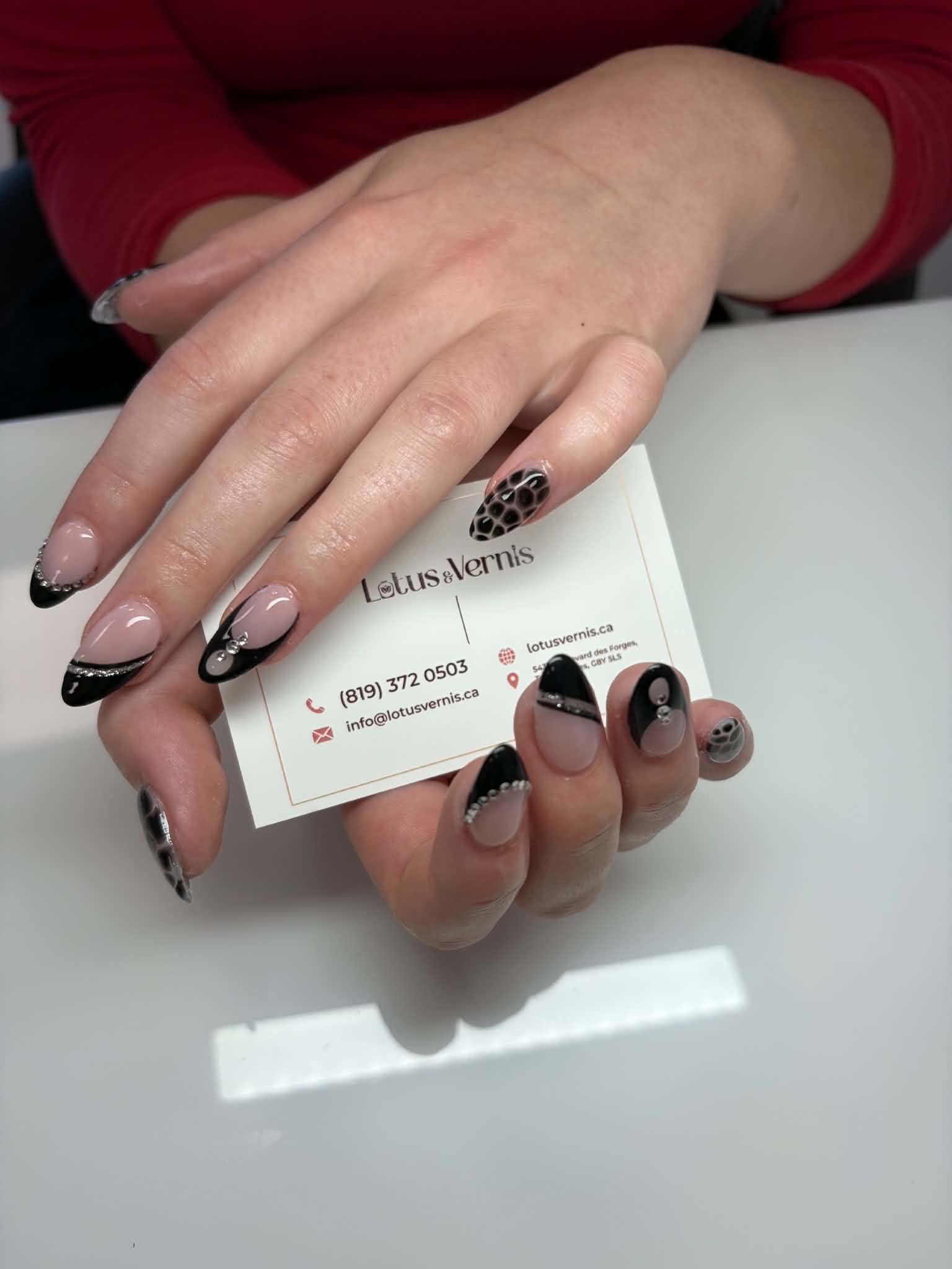 Pose d'ongles amande, French noir avec lignes argentées scintillantes, strass et ongles motif serpent