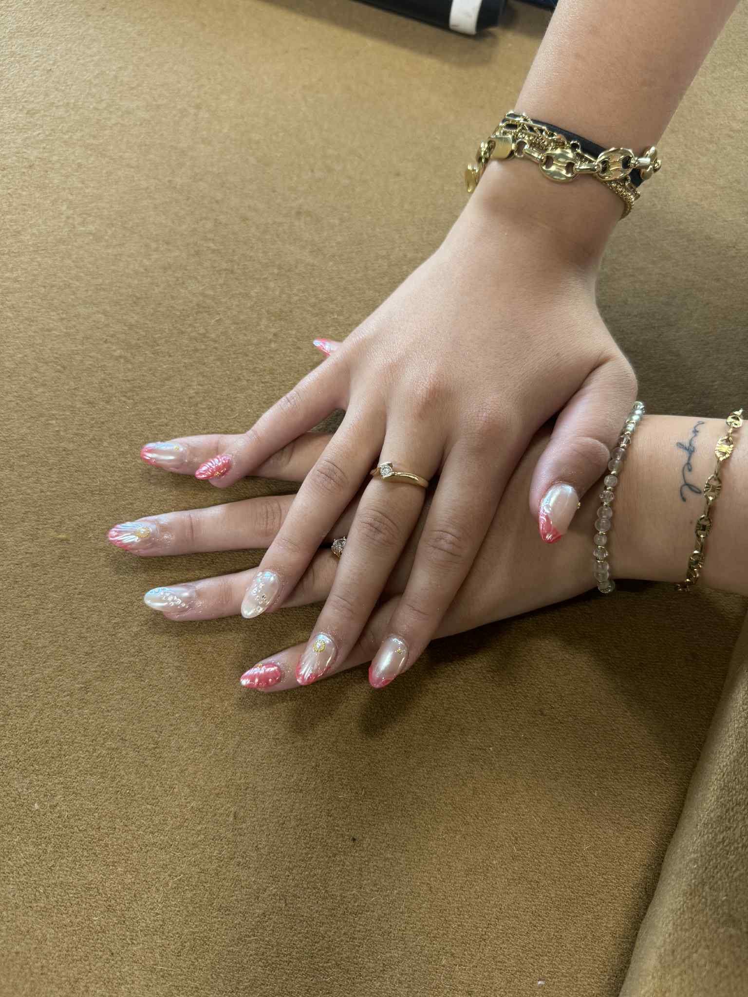 Pose d'ongles amande, effet chromé nacré aux reflets corail et touches dorées