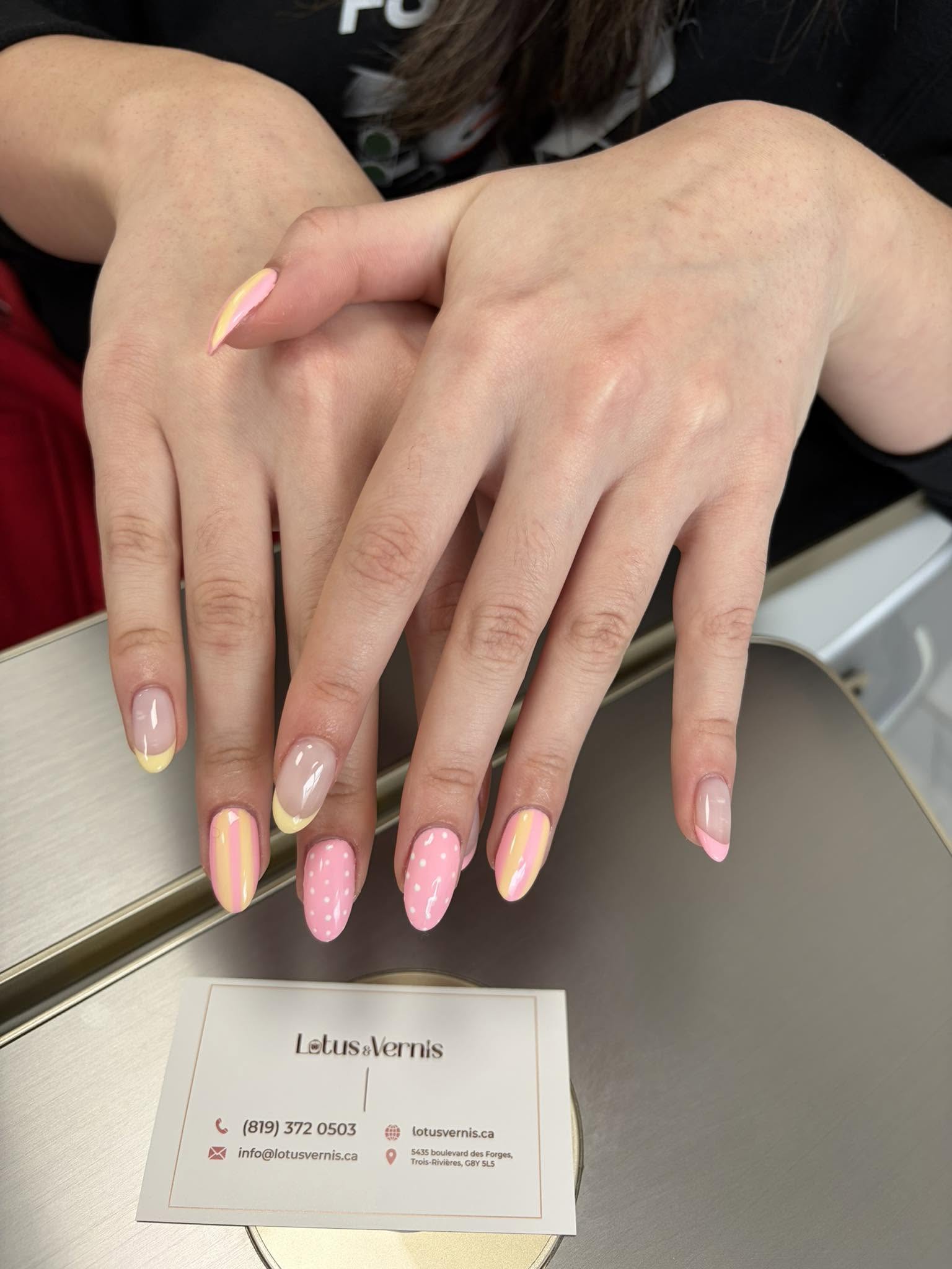 Pose d'ongles amande, motifs pastel rose et jaune, rayures et pois