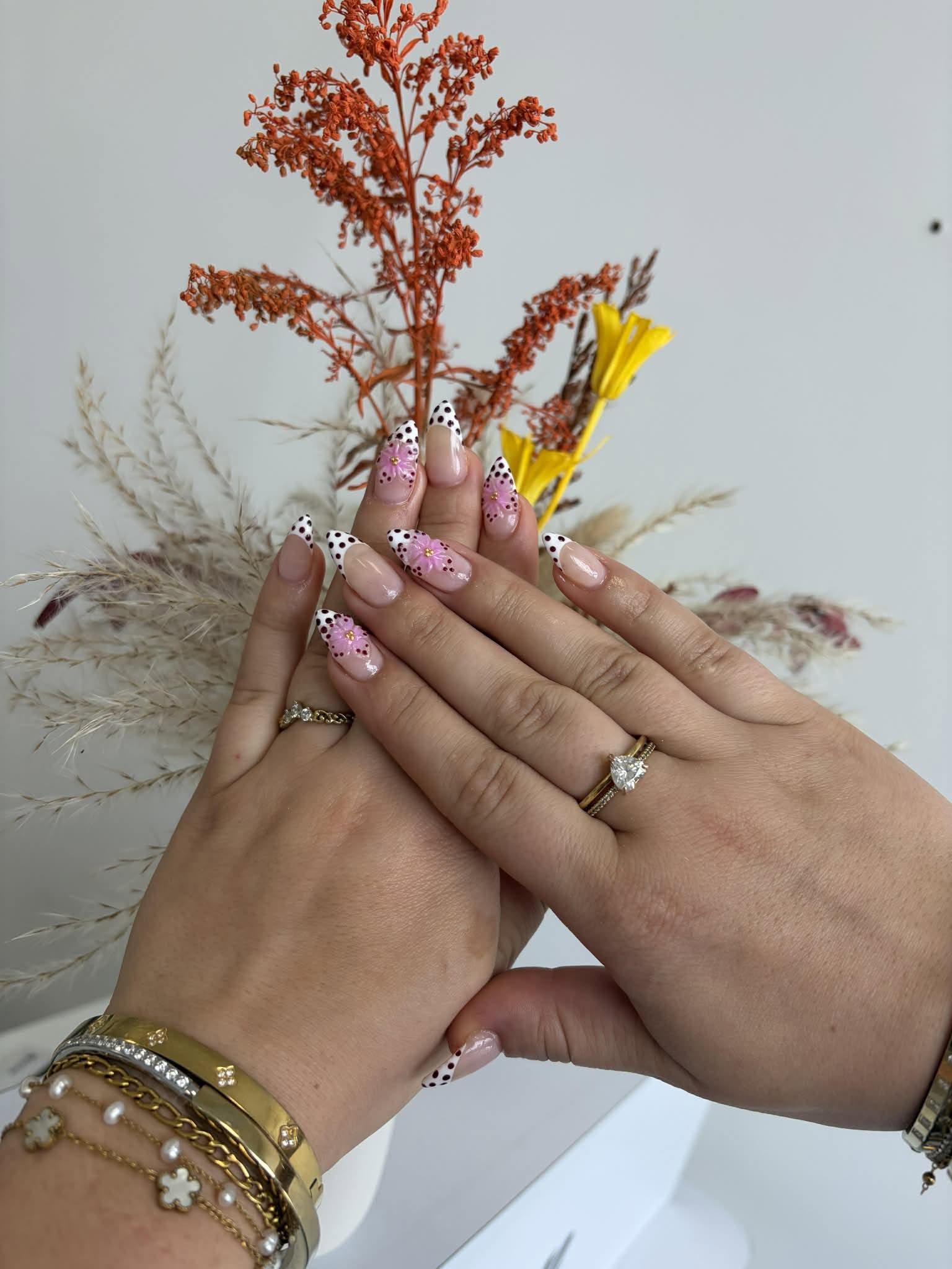 Pose d'ongles amande, French à pois noirs avec fleurs roses en relief